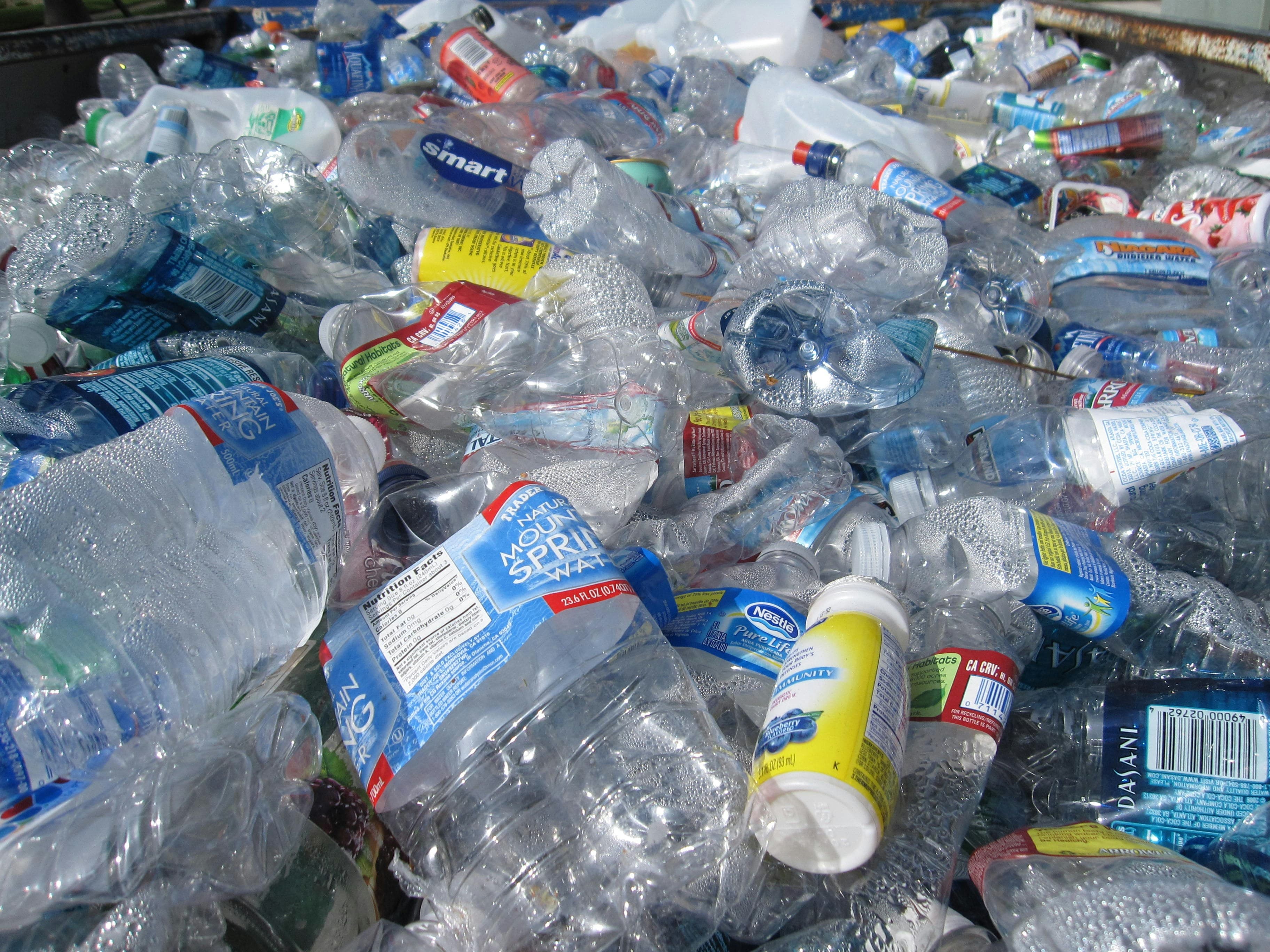 A heap of crushed plastic water bottles and containers ready for recycling